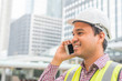 © Nopphon - Young asian civil engineering talking on phone at construction building background.