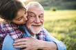 © Halfpoint - A small girl with grandfather outside in spring nature, having fun.