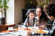 © leszekglasner - Happy african american family eating lunch together at restaurant and having fun