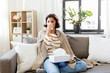 © Syda Productions - healthcare, cold, hygiene and people concept - sick woman blowing her runny nose in paper tissue at home