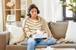 © Syda Productions - healthcare, cold, hygiene and people concept - sick woman in blanket taking paper tissue from box at home