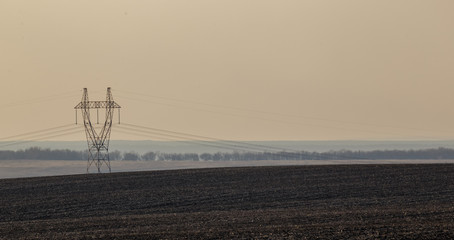  Power line in the field. Fog on the horizon.