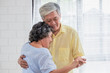 © weedezign - asian seniors couple enjoy dancing in living room at home.aging at home concept.