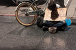 Homeless beggar man sleeps on the sidewalk and asks for money
