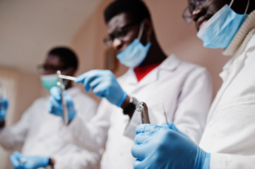 close uo of three african american male doctors colleagues with tools at hands in clinic.