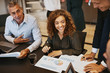 © Flamingo Images - Smiling young businesswoman discussing graphs with office collea