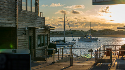 Wall Mural - Pier facing beautiful ocean sunset view, yachts in the background