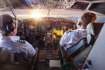 Pilots in the cockpit during a flight with commercial airplane.