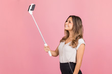 Woman Using Selfie Stick And Phone