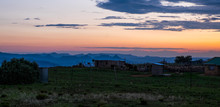 Sunset Landscape Over Small Village With Mountains, Clouds And Orange Sky, Lesotho, Africa