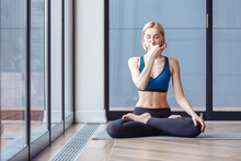 Charming Slim Woman Yoga Instructor Doing Padmasana Basic Yoga Posture For Pranayama In The Spacious Hall. The Concept Of Breath Control Relaxation And Meditation