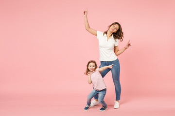 Wall Mural - Woman in light clothes have fun with cute child baby girl. Mother, little kid daughter isolated on pastel pink wall background, studio portrait. Mother's Day, love family, parenthood childhood concept