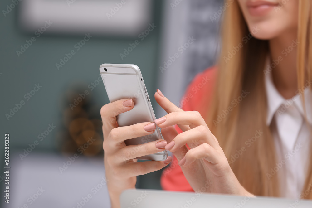 Woman with cell phone indoors, closeup