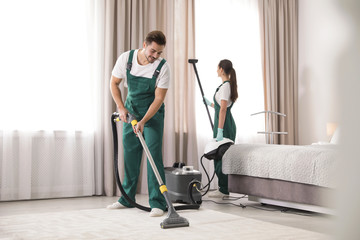 Wall Mural - Team of janitors cleaning bedroom with professional equipment