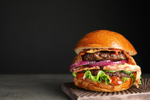 Tasty Burger With Bacon On Table Against Black Background. Space For Text