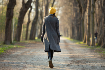 rear view of a young woman walking on an avenue .