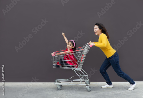 Fotografía happy mom and kid go shopping cart together.