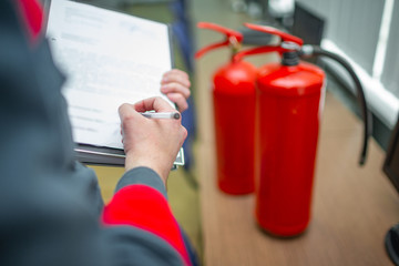 Wall Mural - engineer professional are checking a fire extinguisher using clipboard or checking industrial fire c