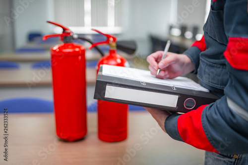 Engineer Professional are Checking A Fire Extinguisher Using Clipboard or checking Industrial fire control system,Fire Alarm controller, Fire notifier, Anti fire.System ready In the event of a fire.