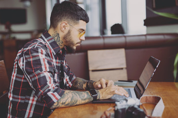 Stylish photographer retouching photos on the laptop computer