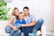 © BillionPhotos.com - Beautiful smiling family sitting at sofa at home