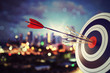 © alphaspirit - Arrow hit the center of target with modern skyline background. Business target achievement concept. 3D Rendering