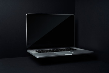 Laptop floating on mockup three dimensional black background
