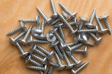 Screws, lying on a wooden table.  Carpenter screws