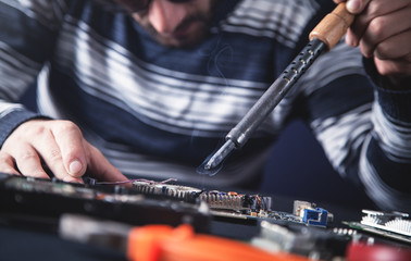 Wall Mural - Computer hardware engineering. Engineer soldering computer motherboard