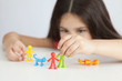 © kaganskaya115 - Happy traditional family figurines. A small child plays with colored plastic figures. Mom, dad, brother, sister, siblings. Family symbol. Adoption. Full family. Face out of focus.