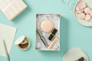 Sticker - image of make up products with gift box on blue background