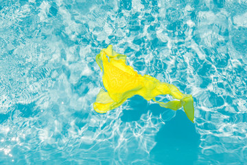 Yellow bikini in clean blue water of the pool.