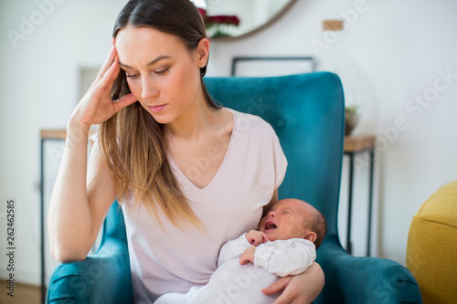 Photographie Stressed Mother Holding Crying Baby Suffering From Post Natal Depression At Home