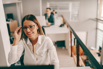 Wall Mural - Smiling Caucasian businesswoman in formal wear and eyeglasses working at office. A lot of good arguments are spoiled by some fool who knows what he is talking about.