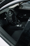 Fototapeta Do przedpokoju - selective focus of black steering wheel near gear shift handle in luxury car