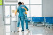 © LIGHTFIELD STUDIOS - african american man hugging happy girlfriend with suitcase in airport