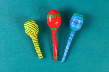 Diy cinco de mayo maracas from eggs, spoons and cereals on a green background.