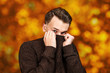 © vika33 - portrait White young guy hiding his face in sweater on orange, red autumn background