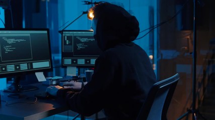 Poster - cybercrime, hacking and technology concept - asian male hacker in mask writing code or using computer virus program for cyber attack in dark room at night