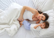 © dinaphoto - Portrait of a pregnant mother and son on the bed. The view from the top.