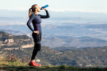 Trail Runner Drinking Water While Looking Landscape From Mountain Peak.