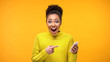Leinwandbild Motiv Joyful young woman pointing at smartphone in hand, online shopping application