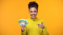 Cheerful Young Woman Pointing At Euro Bills In Hand, Bank Investment, Cashback