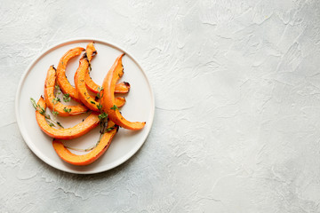 Roasted, baked pumpkin with thyme and salt. Healthy vegan food.