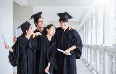 Young asian man woman graduated holding certificate standing in line in front of university building on graduation day. Success happy team work together education celebration concept panoramic banner.