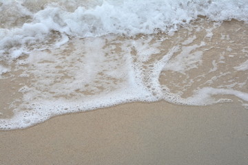 Beautiful soft waves of Blue Ocean with Sandy Beach Background close up. Sea sand wallpaper