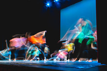 Group Of Dancer In Colored Clothes Dancing On The Stage In Long Exposure