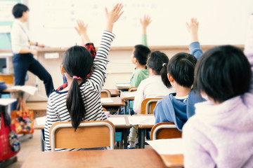教室で手を上げる小学生