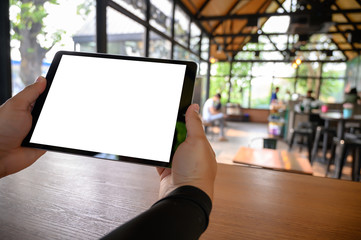 Wall Mural - businessman hand working on tablet on wooden desk tablet with blank screen mockup Digital tablet computer