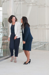 Canvas Print - Two female coworkers laughing in office hall